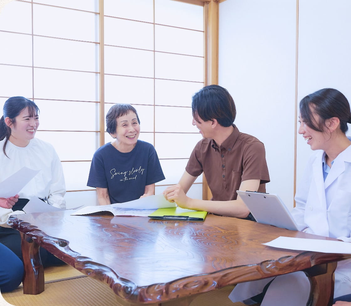 和室のテーブルを囲んで打ち合わせをする多職種のスタッフ