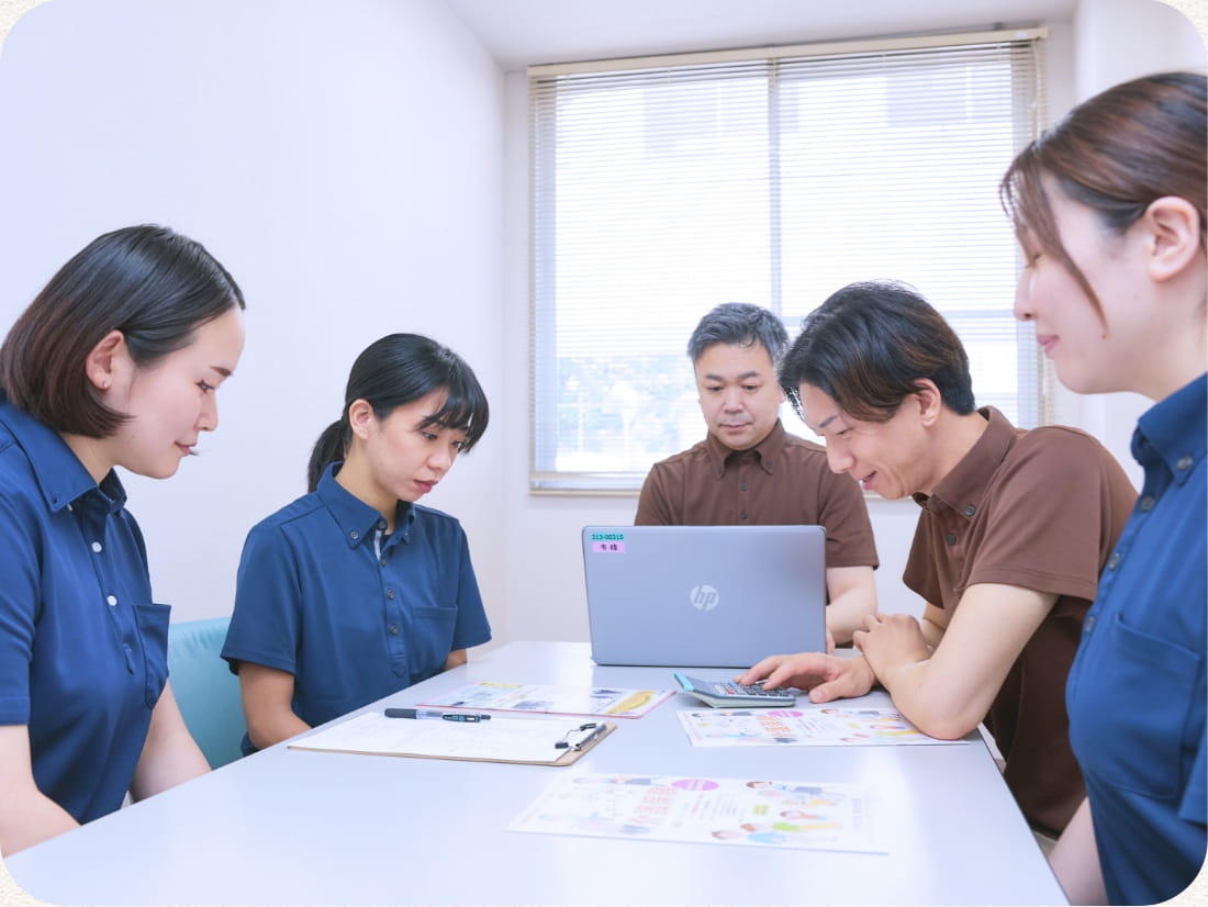 会議室で資料を囲んで話し合う職員たち