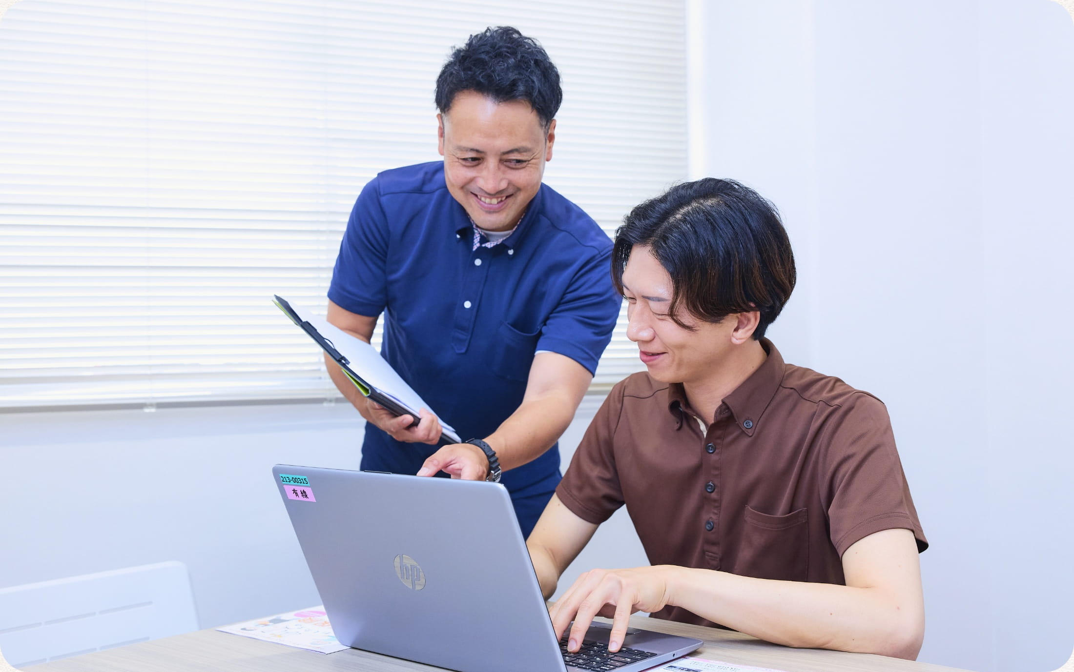 パソコンを見ながら指導する先輩職員と若手職員