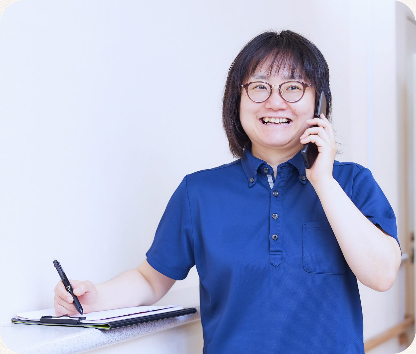 電話で連絡調整をしながら記録を取るケアマネジャー