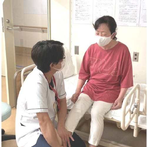 理学療法士とマシーンを使ってリハビリを行う利用者さま