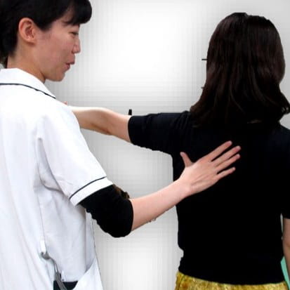 平行棒を使って歩行の練習を行う利用者さま