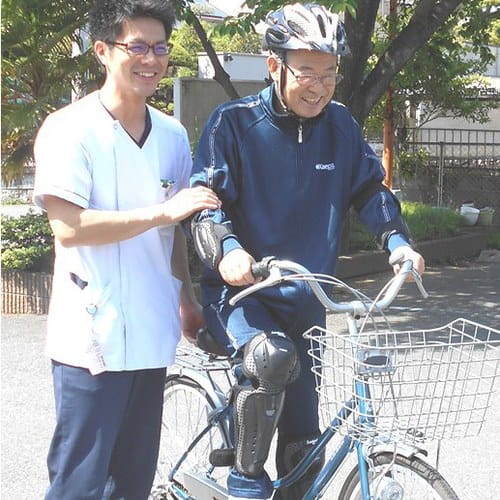 スタッフに見守られながら運動する利用者さま