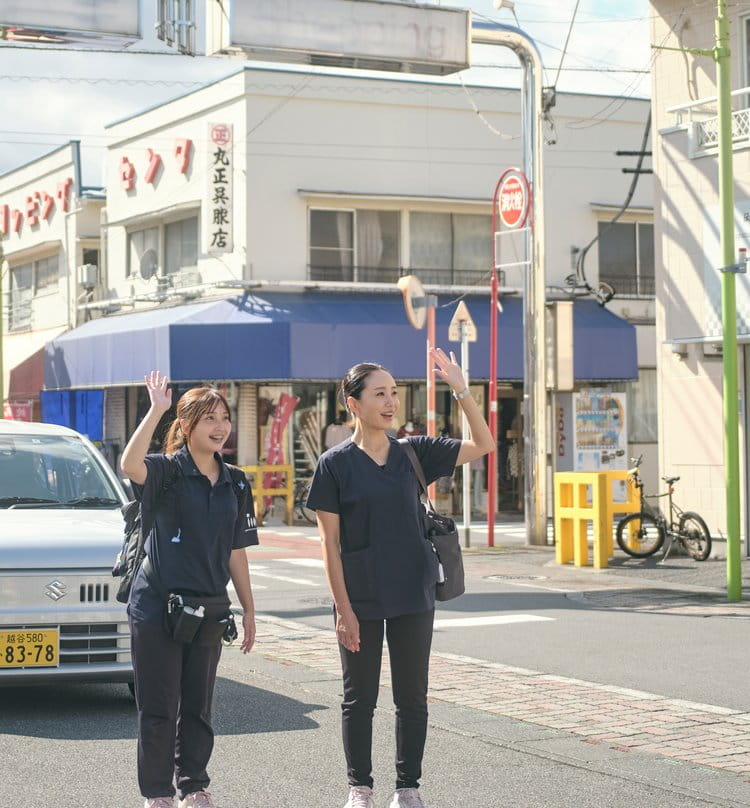 訪問先へ向かう途中、商店街で車から降りる訪問スタッフ